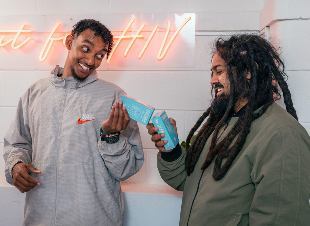 Photo of two people holding condom packets